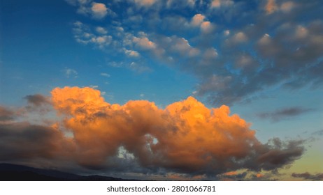 beautiful and dynamic clouds due to rain in a clear and blue sky, on the sunset beach