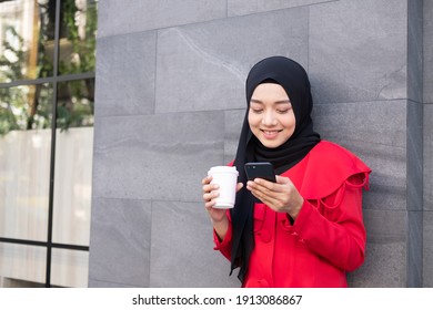 Beautiful East Asian Islamic Women Wearing Hijab With Formal Dress.  Holding Coffee Cup And Walking In Urban City Area, Feeling Happy And Smile. People Lifestyle Concept With Copy Space.