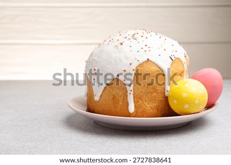 Beautiful Easter cake and eggs on light grey table. Space for text