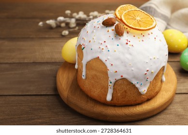 Beautiful Easter cake, eggs and willow on wooden table, closeup