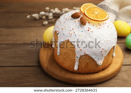 Beautiful Easter cake, eggs and willow on wooden table, closeup