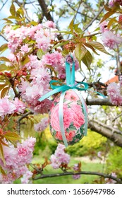 Beautiful Easter egg made with the decoupage technique is hanging on the tree in the garden. 