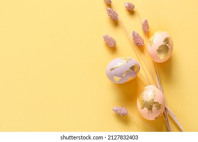 Beautiful Easter Eggs And Dried Flowers On Color Background
