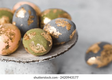 Beautiful Easter eggs with a golden coating were laid on a steel concrete plate on a gray background. The concept of happy Easter 2024. - Powered by Shutterstock