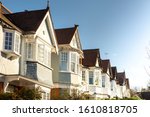 Beautiful Edwardian white houses in a row, first floor level in Church End, Finchley Central, Barnet, London. Warm afternoon light and clear blue sky.