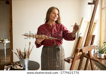 Similar – Image, Stock Photo Elderly woman painter holding a brush in art studio