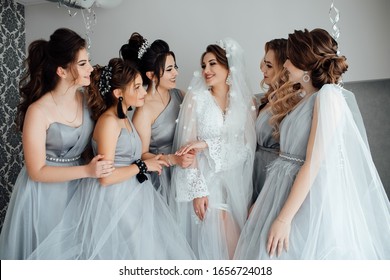 Beautiful and elegant bride with bridesmaids. Beautiful bride is dressed up an elegant wedding robe in home