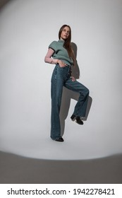 Beautiful Elegant Girl Model In Fashion Vintage Clothes With Knitted Vest And Bell Bottom Jeans Poses In Studio