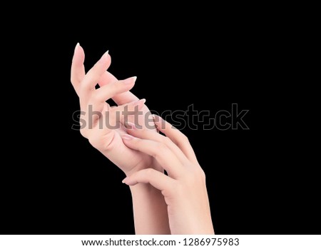 Beautiful and elegant woman hands isolated on black background, concept of applying moisturizing cream and body care, closeup.