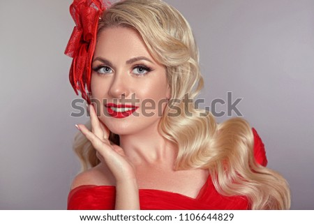 Beautiful elegant woman with red lips in fashion hat laughing over gray studio background. Attractive blonde model with happy face and teeth whitening. Pretty blond portrait.