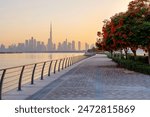 beautiful embankment with flowering trees overlooking the downtown Dubai at sunset, UAE