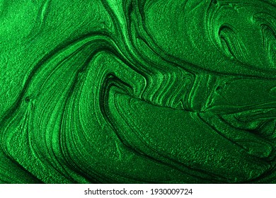 Beautiful emerald green stains of liquid nail polish,fluid art technique.Monochrome marble background.Liquid stripy paint texture.Nail lacquer flow modern backdrop. Minimalism concept.Copy space.