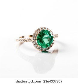 A beautiful emerald ring with sparkling diamonds isolated on a white background. - Shutterstock ID 2364337859