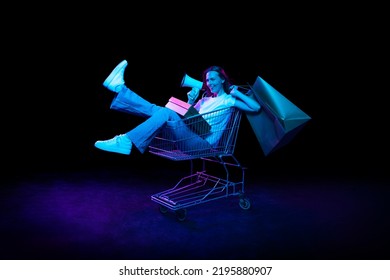 Beautiful emotional girl inviting for shopping, black friday, seasonal sales isolated over dark background in neon light. Cyber monday and online purchases. Art, fashion, emotions, ad - Powered by Shutterstock