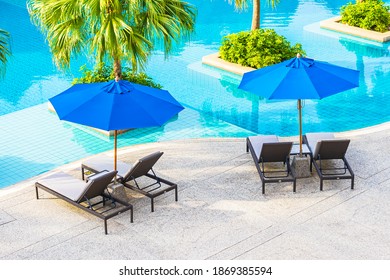 Beautiful Empty Chair With Umbrella Around Outdoor Swimming Pool In Hotel Resort For Vacation Travel