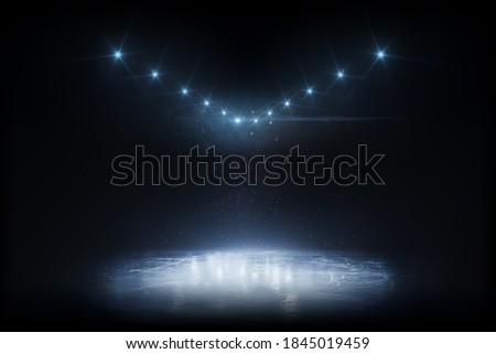 Beautiful empty winter background and empty ice rink with lights. Winter background. Spotlight shines on the rink. Bright lighting with spotlights