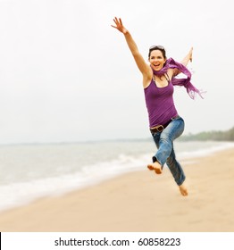 A Beautiful Energetic Young Woman Taking A Great Leap On The Beach