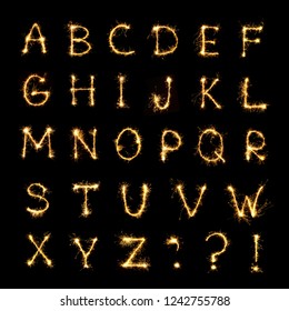 Beautiful english alphabet. Burning sparkler letters isolated on black background. Shiny festive font of Sparklers to overlay on texture for design Holiday postcards, web banners