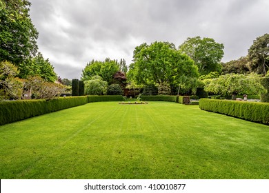 Beautiful English style garden with hedges, & symmetrical type design, with a large open green lawn for parties & open air activities. The garden is designed with European flair, class and tradition. - Shutterstock ID 410010877
