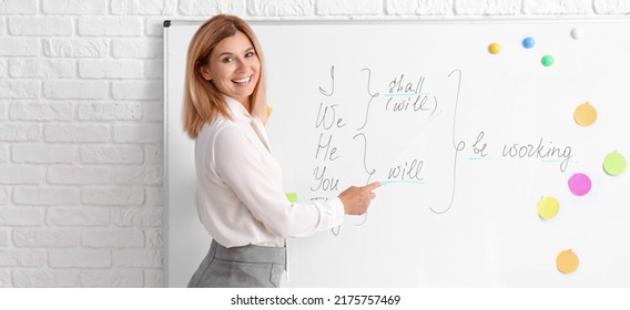 Beautiful English teacher near blackboard in classroom - Shutterstock ID 2175757469