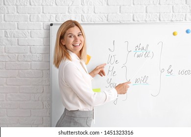 Beautiful English teacher near board in classroom - Shutterstock ID 1451323316