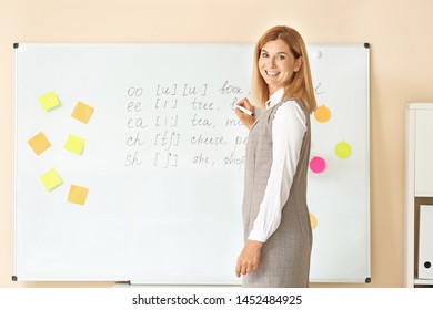 Beautiful English teacher near board in classroom - Shutterstock ID 1452484925