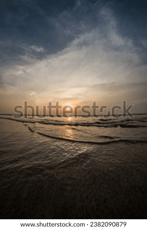 Beautiful epic sunset view from a rocky beach with clear sky in Goa - India