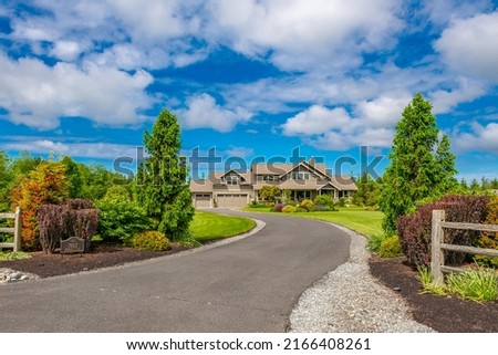 Beautiful estate home on large acreage with lush landscaping, split rail fence and long asphalt paved driveway