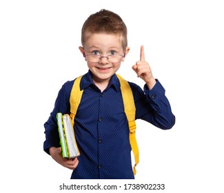 A beautiful European boy with blue eyes is going to school. Portrait of a first-grader with a briefcase, glasses and notebooks (books). Primary school education, pre-school education.