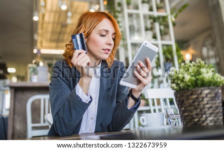 Beautiful European girl using her tablet to do internet banking, online shopping while she holding credit card in another hand. Paypal concept. Internet Banking concept. - Image
