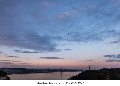 Beautiful European Lisbon, Portugal after sunset with evening sky and purple blue clouds. Evening cityscape with bridge, river and airplane  - Shutterstock ID 2149568057