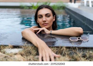 Beautiful European Woman In Black Swimsuit Posing Outside At Villa In Swimming Pool, On Vacation, Perfect Shape, Good Body, Tanned, Fit, Wearing Trendy Brown Sunglasses