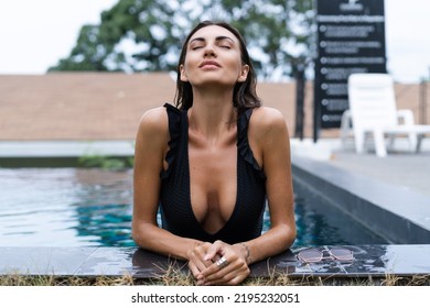 Beautiful European Woman In Black Swimsuit Posing Outside At Villa In Swimming Pool, On Vacation, Perfect Shape, Good Body, Tanned, Fit, Wearing Trendy Brown Sunglasses