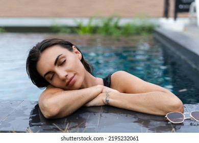 Beautiful European Woman In Black Swimsuit Posing Outside At Villa In Swimming Pool, On Vacation, Perfect Shape, Good Body, Tanned, Fit, Wearing Trendy Brown Sunglasses