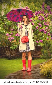 Beautiful European Woman Dressed Up In A Raincoat With An Umbrella In The Park. Style And Fashion. Instagram Image Filter Retro Style