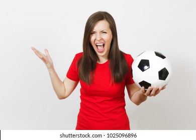 Beautiful European Young Angry Screaming Woman, Football Fan Or Player In Red Uniform Holding Soccer Ball Isolated On White Background. Sport, Play Football, Health, Healthy Lifestyle Concept