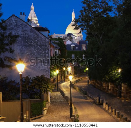 Beautiful evening view of Montmartre street and the Sacre-Coeur basilica in Paris, France.