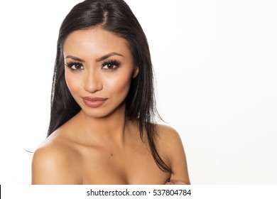 Beautiful exotic woman with dark hair, fresh glowing skin face and bare shoulders portrait.