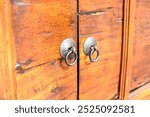 Beautiful Exterior metal door handle on wood Cabinet lid, Steel and wooden door handle. wooden aged textured door with rings door handles.