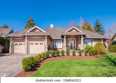 Beautiful exterior of newly built luxury home. Yard with green grass and walkway lead to front entrance.
