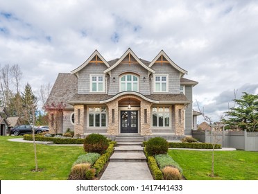 Beautiful Exterior Of Newly Built Luxury Home. Yard With Green Grass And Walkway Lead To Front Entrance.