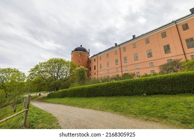 Beautiful exterior view of famous Uppsala Castle. Green plants and trees on front and grey clouds on background. Sweden. 