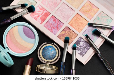 Beautiful Eye Shadow Box, Rainbow Highlighter, Makeup Brushes, Baked Bronzer On A Dark Background