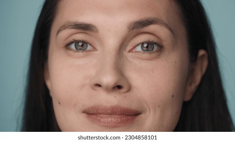 Beautiful eyes of a young woman. Close up of a woman's face with clean, healthy skin on a blue background. Good vision and eye care. Contact lenses. Natural female beauty. - Powered by Shutterstock