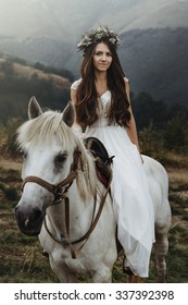 beautiful fabulous happy  bride riding a horse  on the background of   the stunning mountains