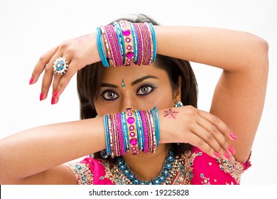 Beautiful face of a Bengali bride with her arms across her head covered with colorful bracelets, isolated