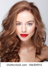 Beautiful Face Of A Fashion Model With Blue Eyes.Curly Hair. Red Lips. Studio Portrait. Beauty.