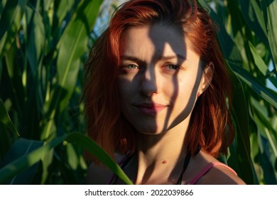 Beautiful Face Of A Girl With Red Hair And Shadow From Plants
