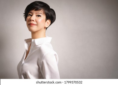 Beautiful Face Of A Mature Confident Asian Business Woman In White Long-sleeve Shirt Stand Looking At Camera With Positive And Satisfying. Studio Portrait, Copy Space, Professional, Leadership Concept