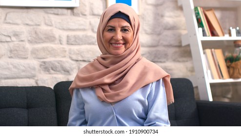 Beautiful face portrait of happy mature middle-aged woman in hijab. Old lady in turban looking at camera with healthy cheerful smile. 
